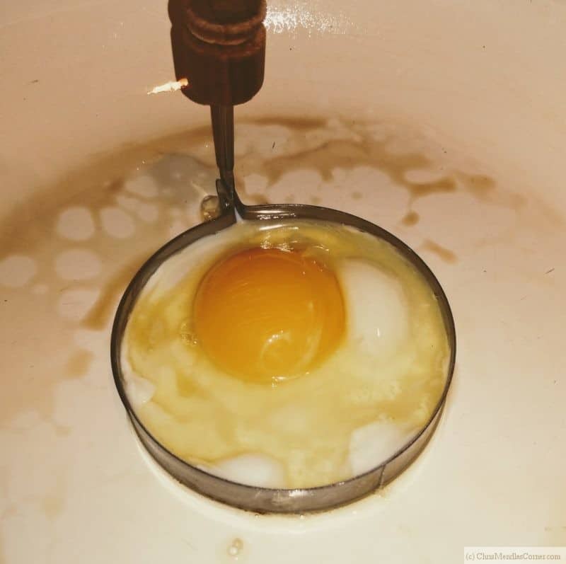 Carefully crack an egg into the ring. 